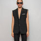 Upcycled ripped tailored vest with a “brooch” with recycling logo and rips all around the lapel, bottom, and arm holes.